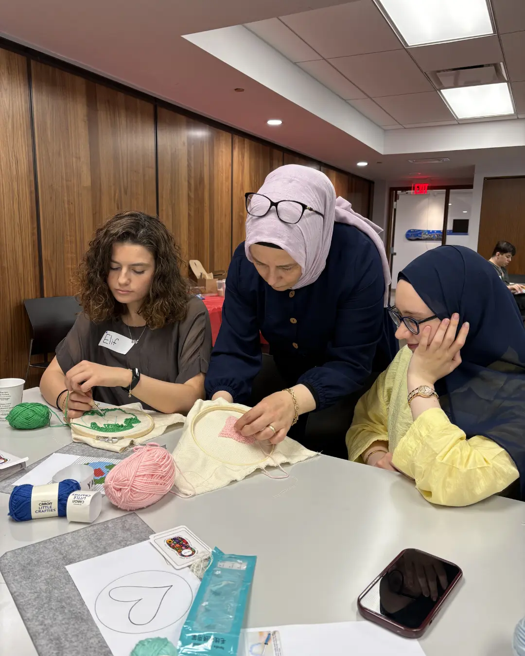 Participants creating punch knitting art pieces at the Threads of Peace workshop at Kitchener Public Library as part of United in Voices preparations.