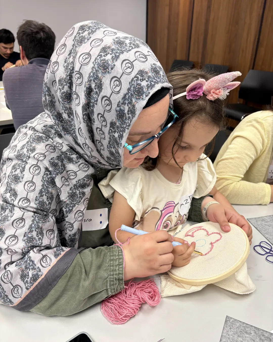 Participants creating punch knitting art pieces at the Threads of Peace workshop at Kitchener Public Library as part of United in Voices preparations.