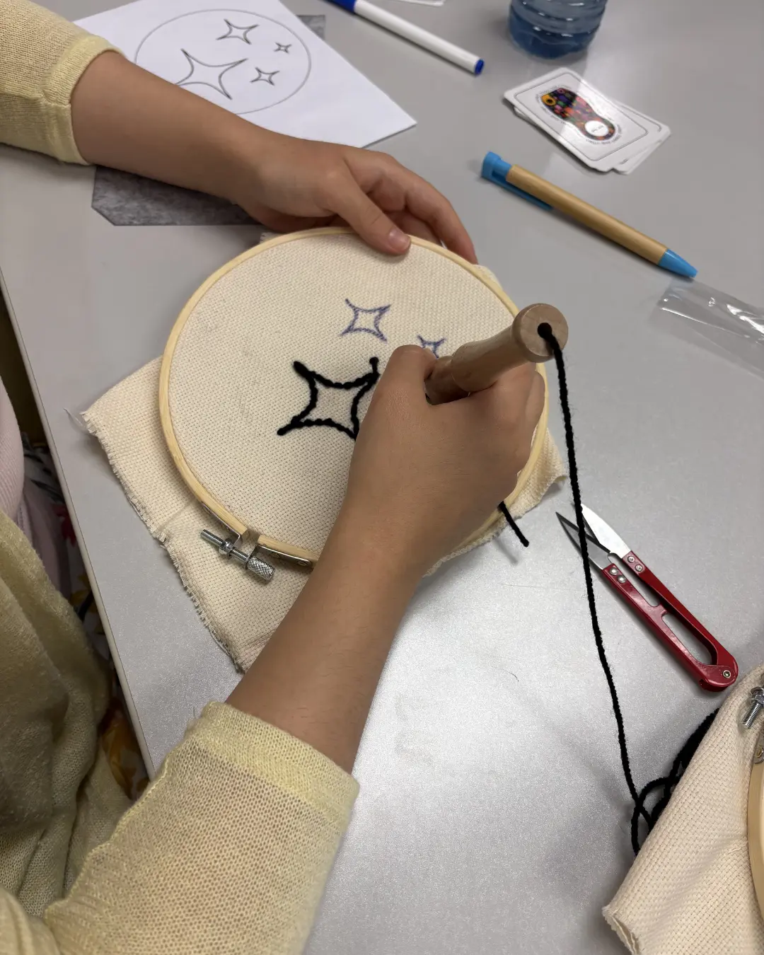 Participants creating punch knitting art pieces at the Threads of Peace workshop at Kitchener Public Library as part of United in Voices preparations.