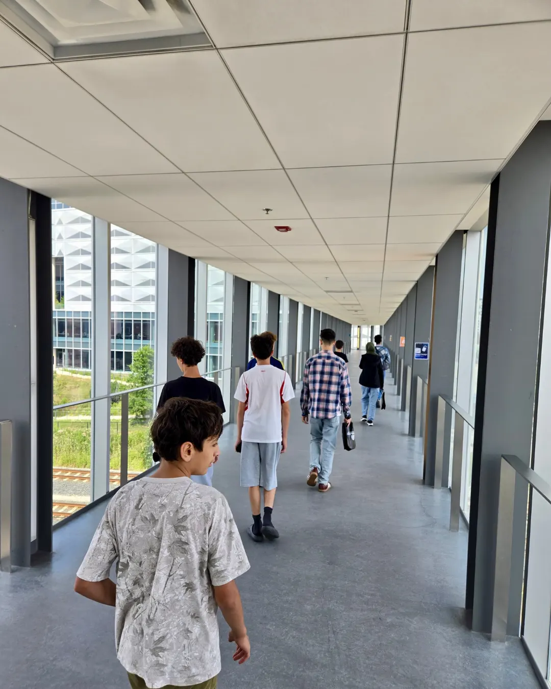 GRFS students touring a modern academic building at the University of Waterloo.