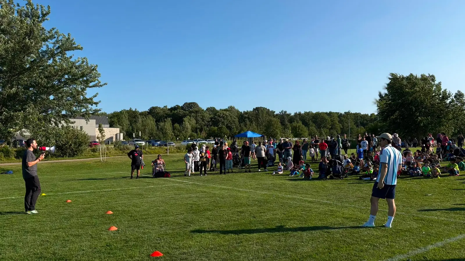 Coach addressing children and families at the opening GRFS Football for Learning soccer session.