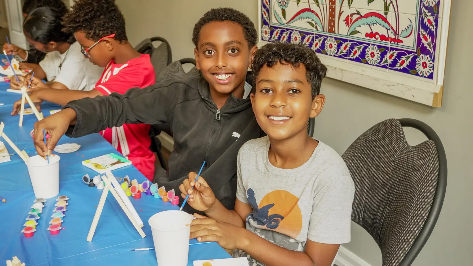 Children painting mini canvases during a creative workshop at GRFS Kids To Camp 2026.