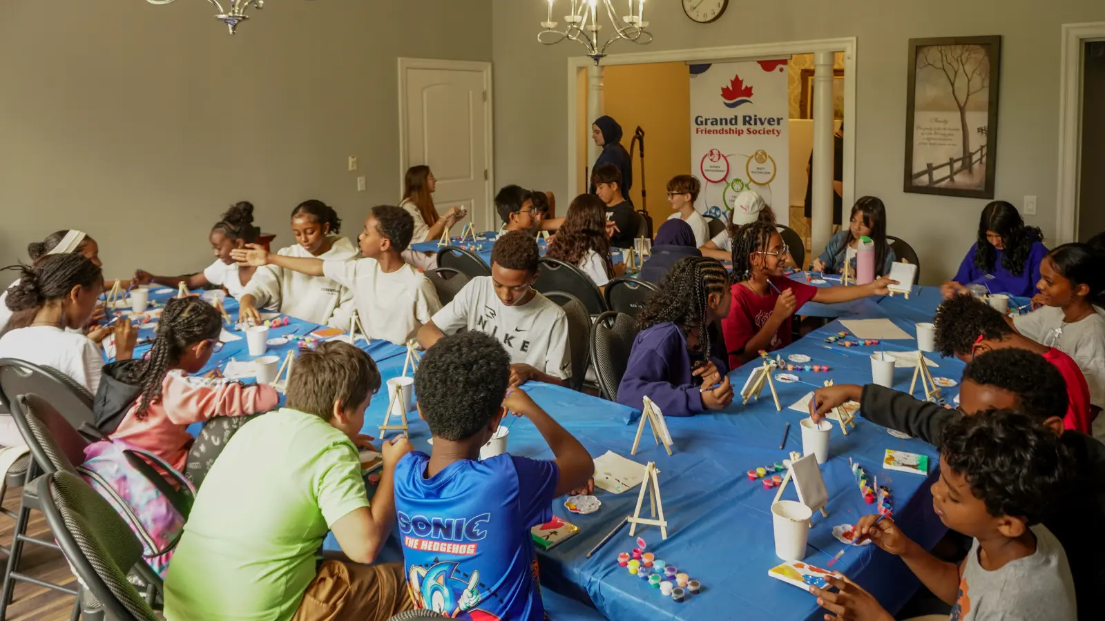 Kids To Camp 2026 participants working together on painting projects during an indoor creative session.