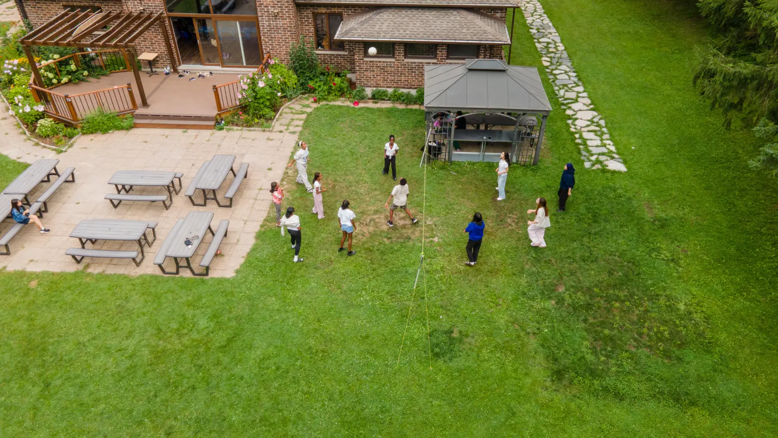 Aerial view of children playing volleyball and outdoor games during GRFS Kids To Camp 2026.