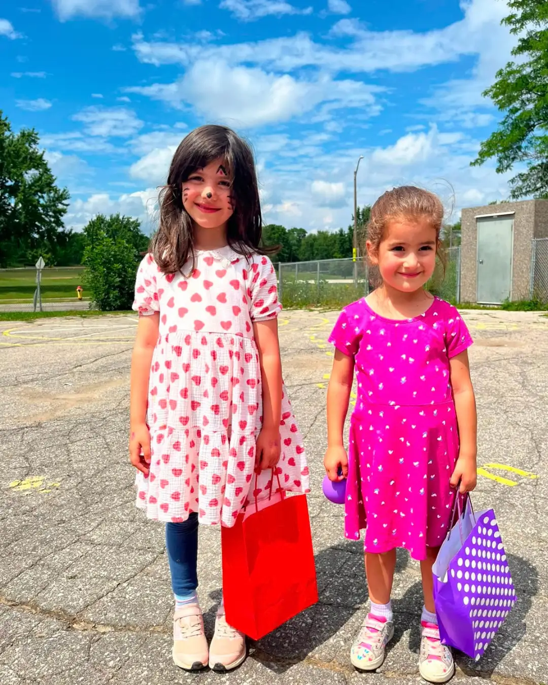 Two children with face paint and gift bags outdoors at GRFS Summer School 2026