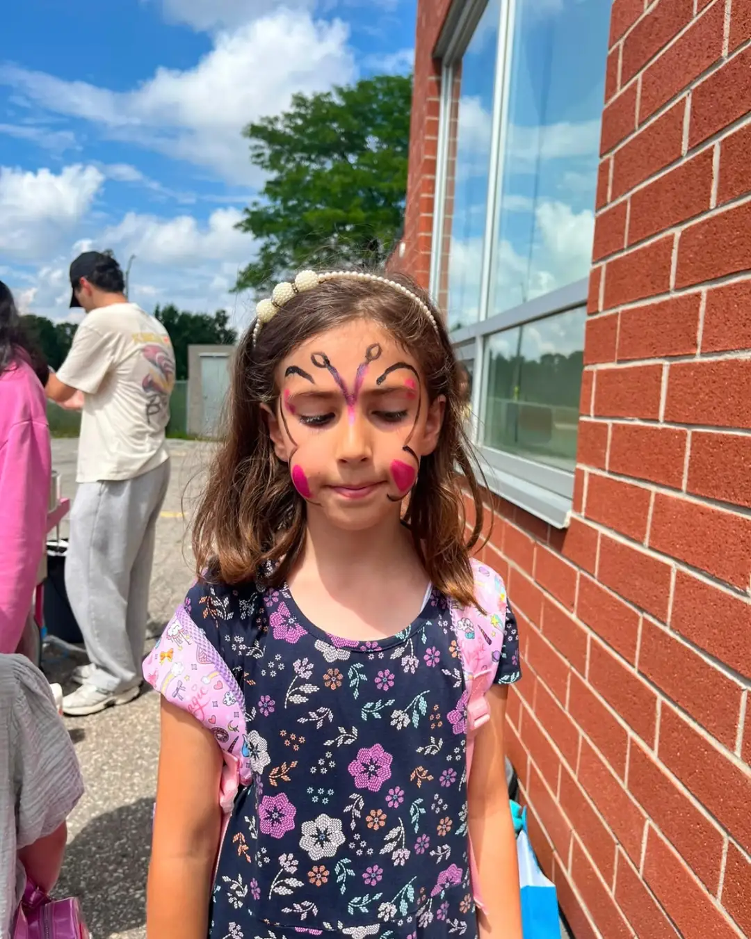 A child showing butterfly face paint outdoors at GRFS Summer School 2026