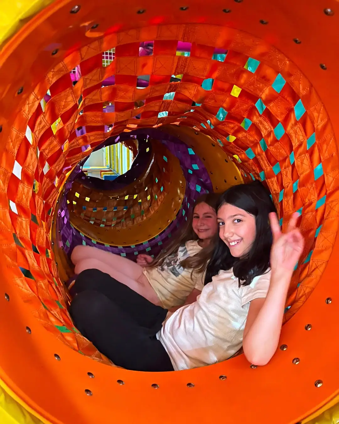 Two children smiling inside a colourful play tunnel at GRFS Summer School 2026