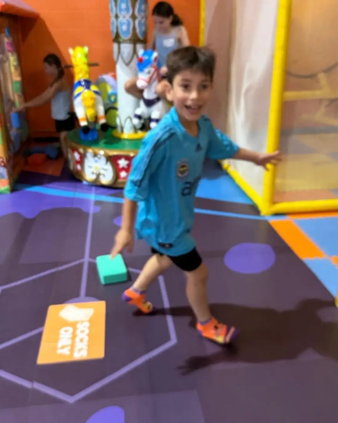 A child playing with a foam block at an indoor recreation venue at GRFS Summer School 2026