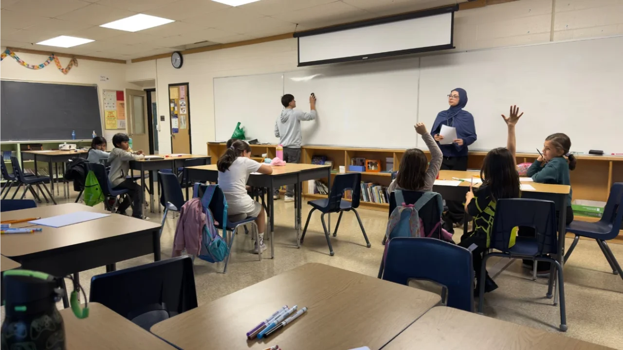 Students raising their hands as a classmate writes on the whiteboard during Football for Learning Fall 2026.