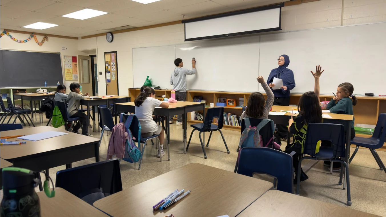 Students raising their hands as a classmate writes on the whiteboard during Football for Learning Fall 2026.