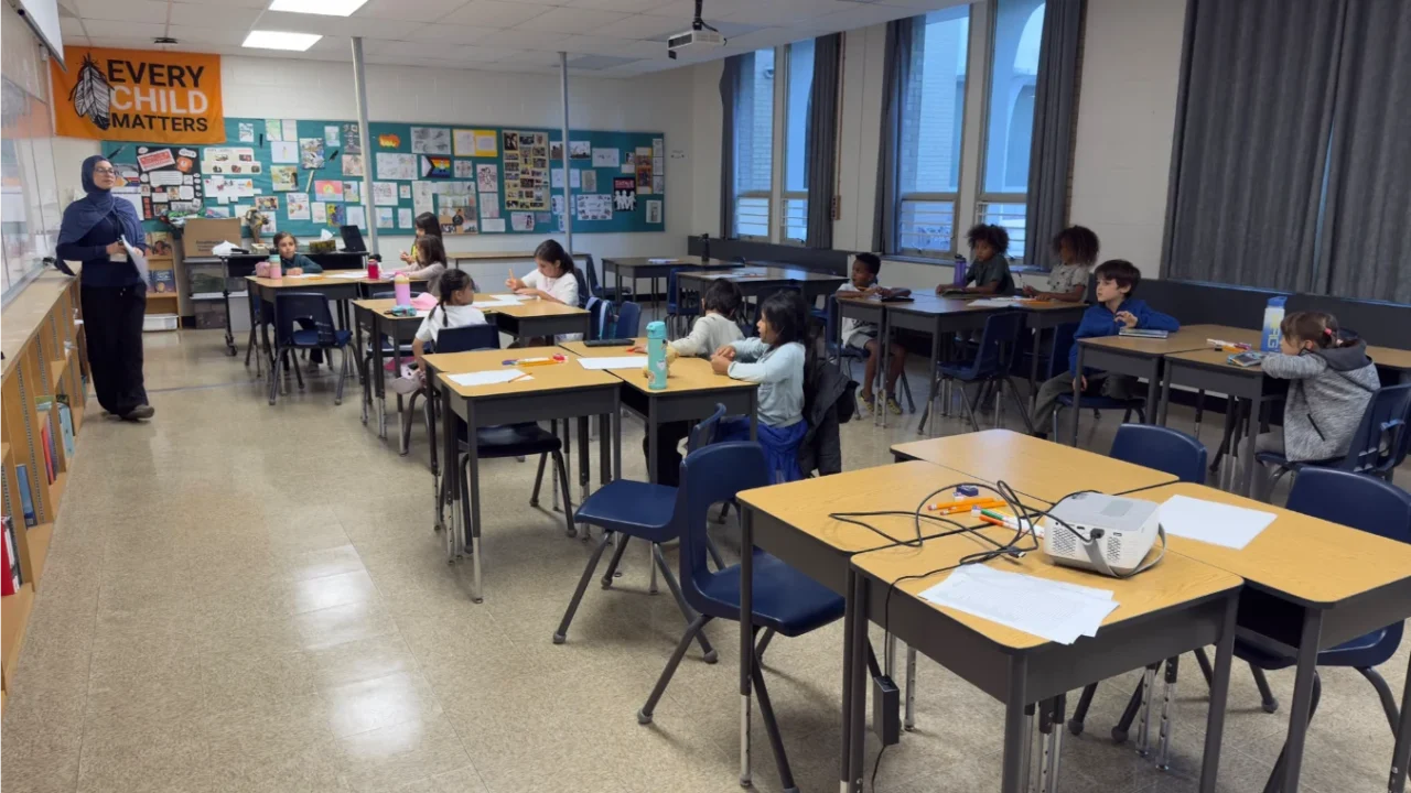 Students listening to an instructor at the whiteboard during an in-person Football for Learning class.
