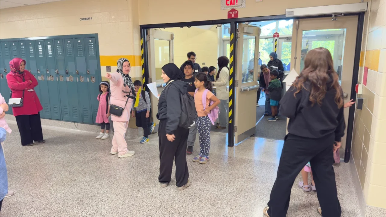 Children and adults gathering in the school hallway before Football for Learning sessions.